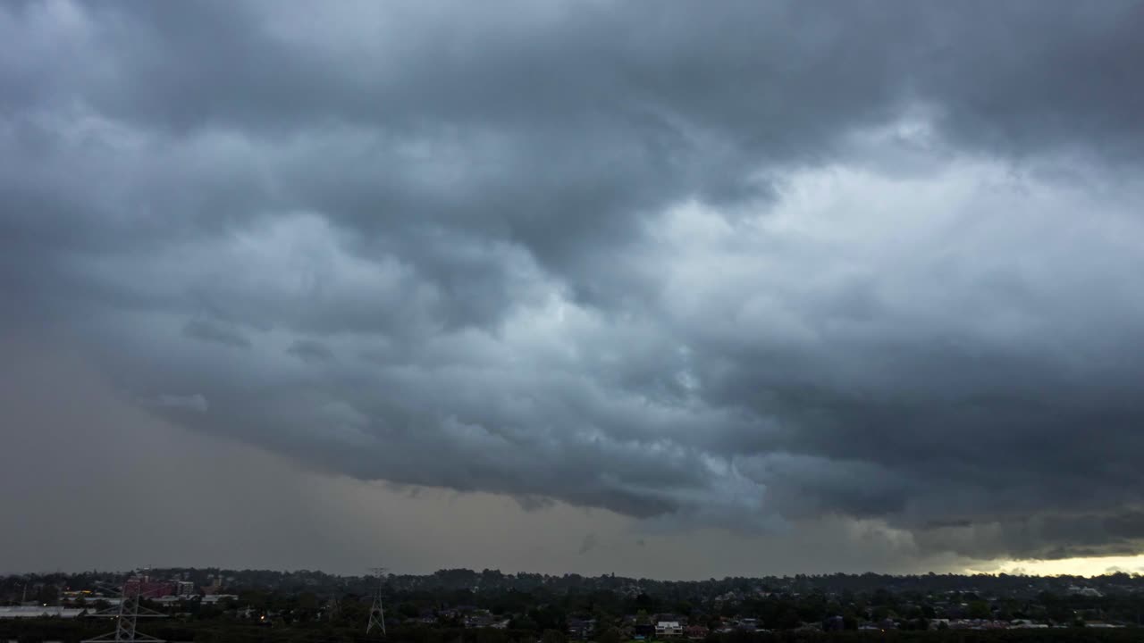 비가 쏟아지고 도시 위로 지나가는 거대한 구름 형성의 어둡고 변덕스러운 시간 경과