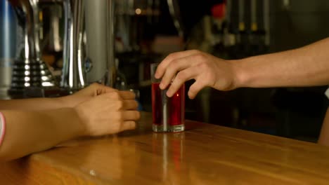 Woman-being-served-drink-at-the-bar