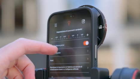 hand setting up gimbal parameters on smartphone. closeup shot