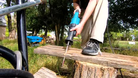 male cutting lumber in the backyard for fire wood