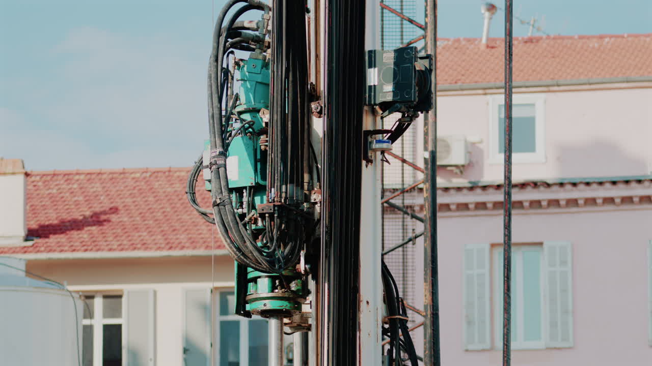 Close up of industrial drilling equipment with hydraulic cables and metal framework
