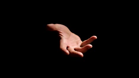 a hand on a black background invites you to enter. climate lighting. recorded in 4k 60fps.