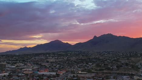 Aerial-Drone-Shot-Of-Franklin-Mountains-Seen-From-West-El-Paso-Texas-During-Beautiful-Colorful-Sunrise-With-Large-Rainbow-Clouds-In-The-Background