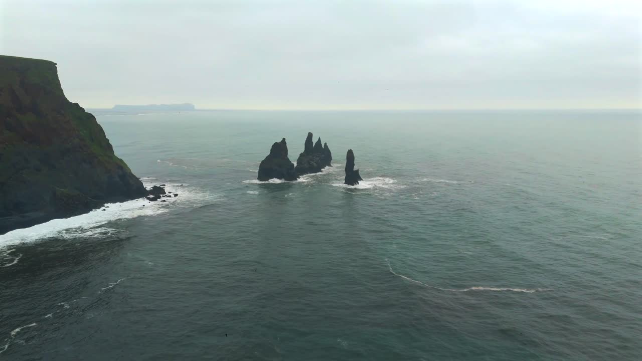 sobrevolar la playa de reynisfjara para presenciar el increíble contraste de arena negra y olas estrelladas, creando un paisaje hipnotizante a diferencia de cualquier otro