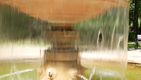 a small fountain with water in the summer park - a place of rest from the heat
