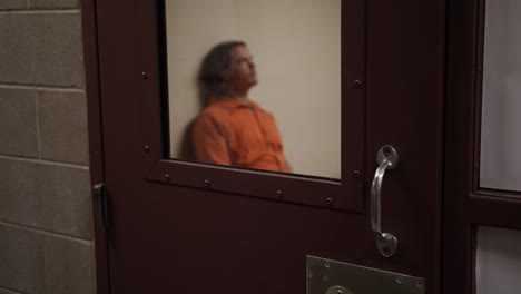 hombre triste y solemne, recluso, prisionero, se sienta solo en su celda de prisión