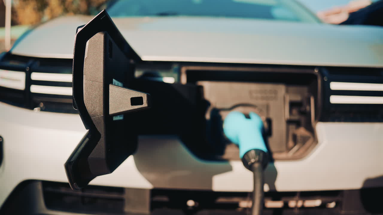 Close up shot of an electric vehicle charging port with cable connected