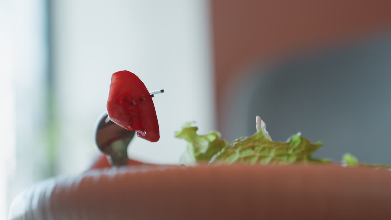 Closeup fork with tomato and lettuce, minimalist tabletop stilllife with single tomato cube skewered above crisp lettuce, soft natural window light, shallow depth of field, muted background, food