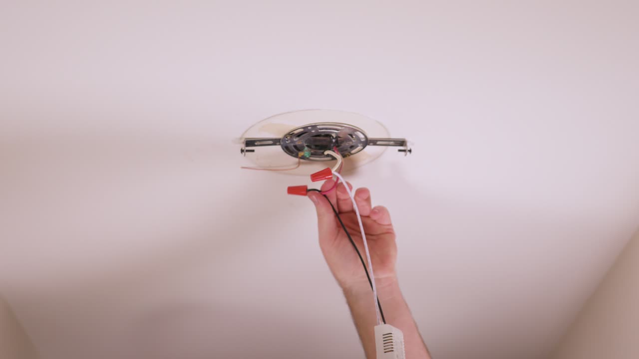 Neatly tucking away the connected wires back into the ceiling