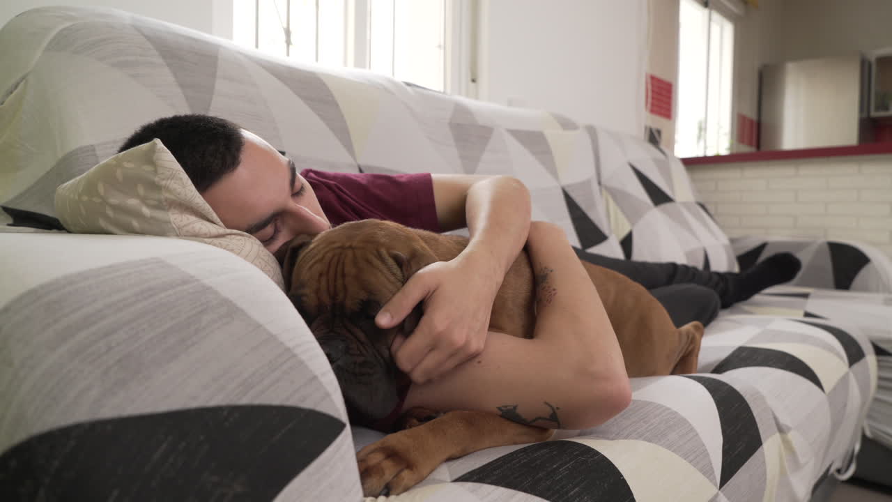 young man with his dog lying on the couch