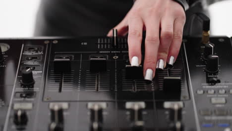 close-up of a dj mixing music on a mixer