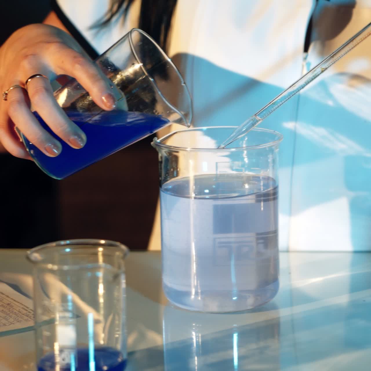 Young woman working in laboratory on experiments. Testing chemicals in laboratory