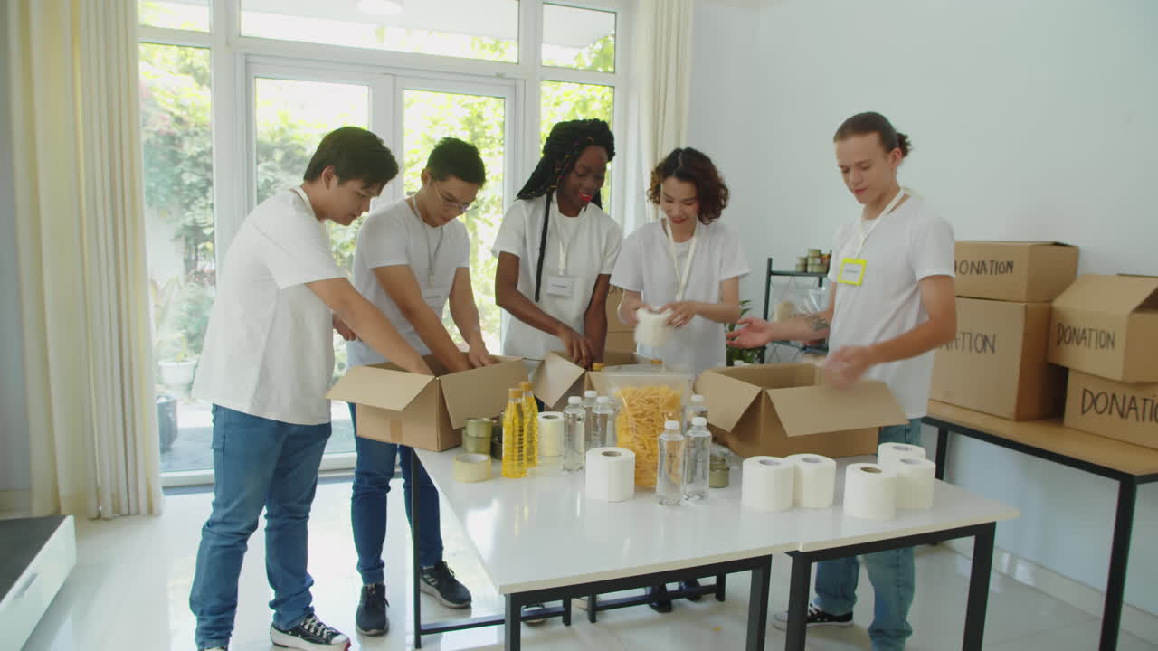 Diverse Volunteers Packing Donation Boxes for Refugees