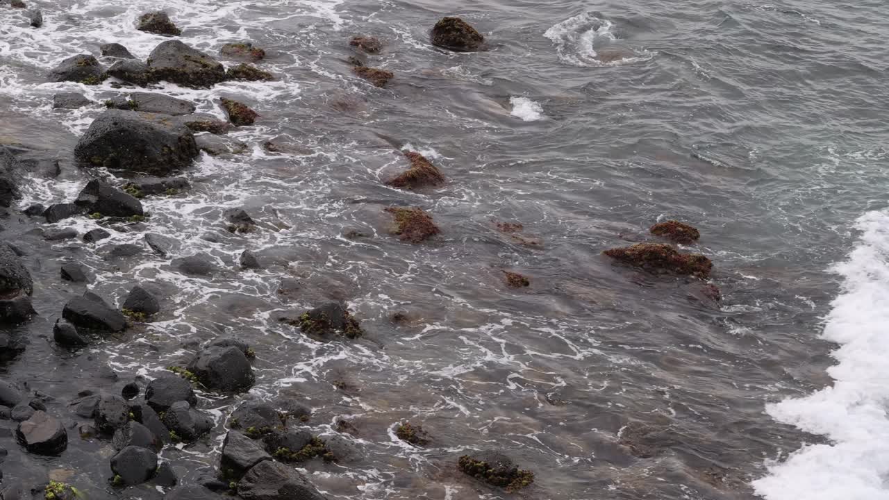 el reflujo y el flujo de las olas sobre las rocas costeras