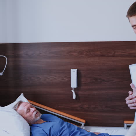visit to the patient. doctor and female visitor come into the hospital chamber to visit sick patient. senior man laying on bed in the hospital.