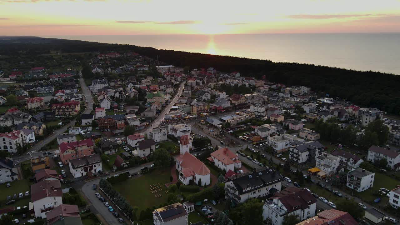 ciudad del pueblo costero de karwia, polonia con puesta de sol en el fondo
