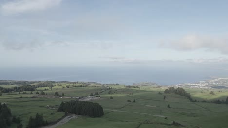 the lush, rolling hills of miradouro pico do carvao, são miguel under a cloudy sky, aerial view