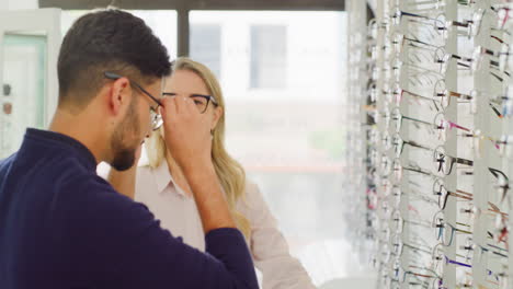 óptica o optometrista ayudando a un cliente