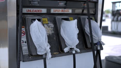 gas pumps at shut down fuel petrol station with plastic bags on all the nozzles due to gas shortage crisis and covid pandemic