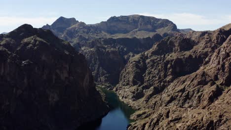 aerial view of a boat on a canyon river in kingman, usa - reverse, tilt, drone shot