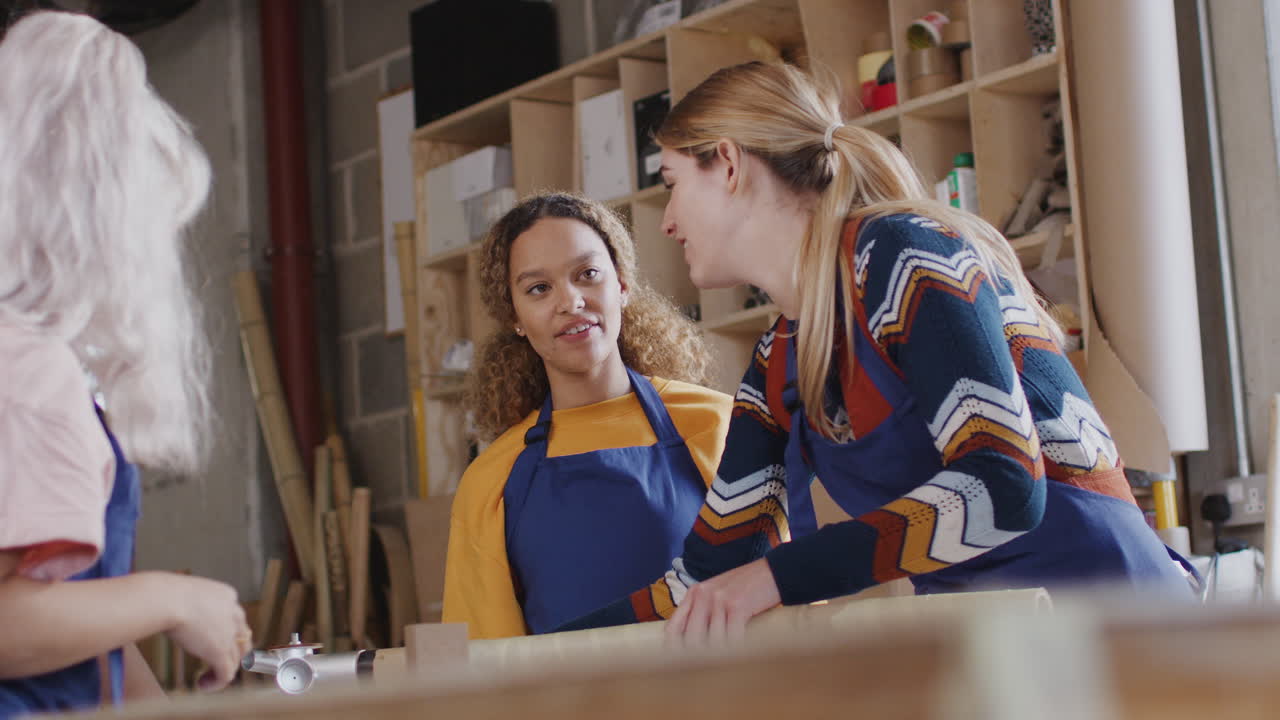 команда женщин-стажеров в мастерской учится собирать ручной велосипедный каркас вместе