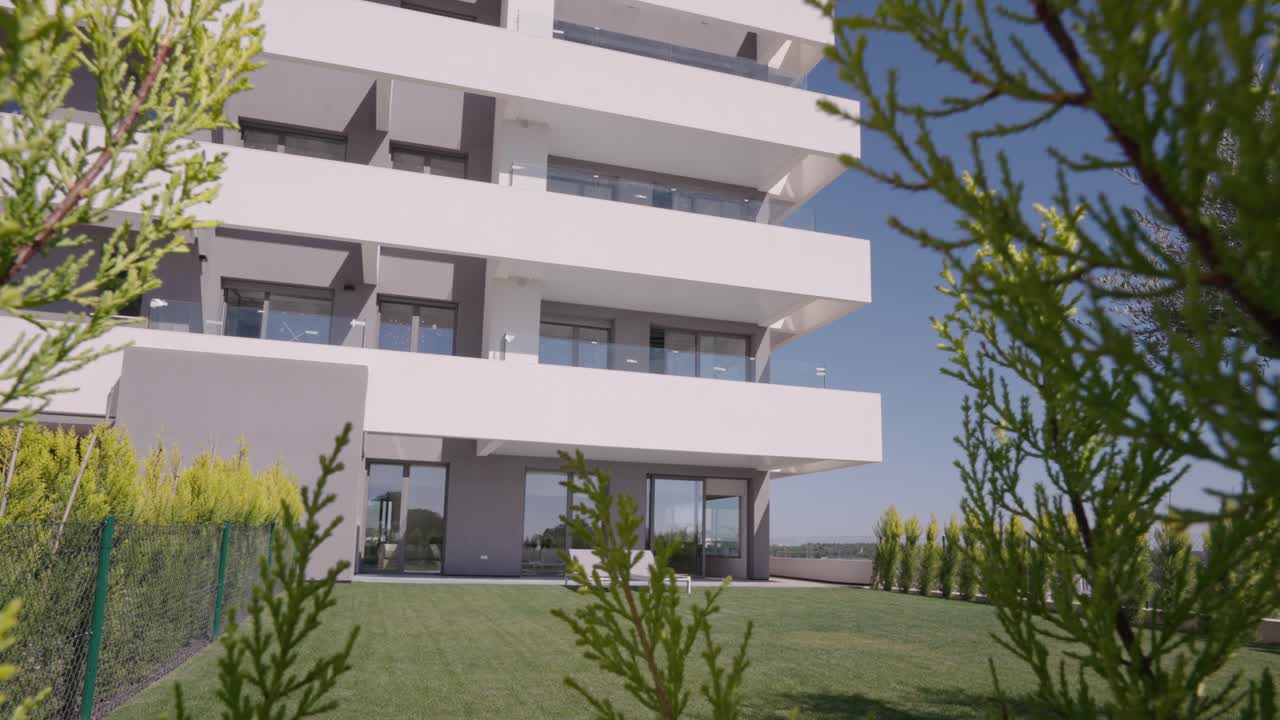 arquitectura moderna que construye formas geométricas superficie blanca, cielo azul y césped y árboles verdes