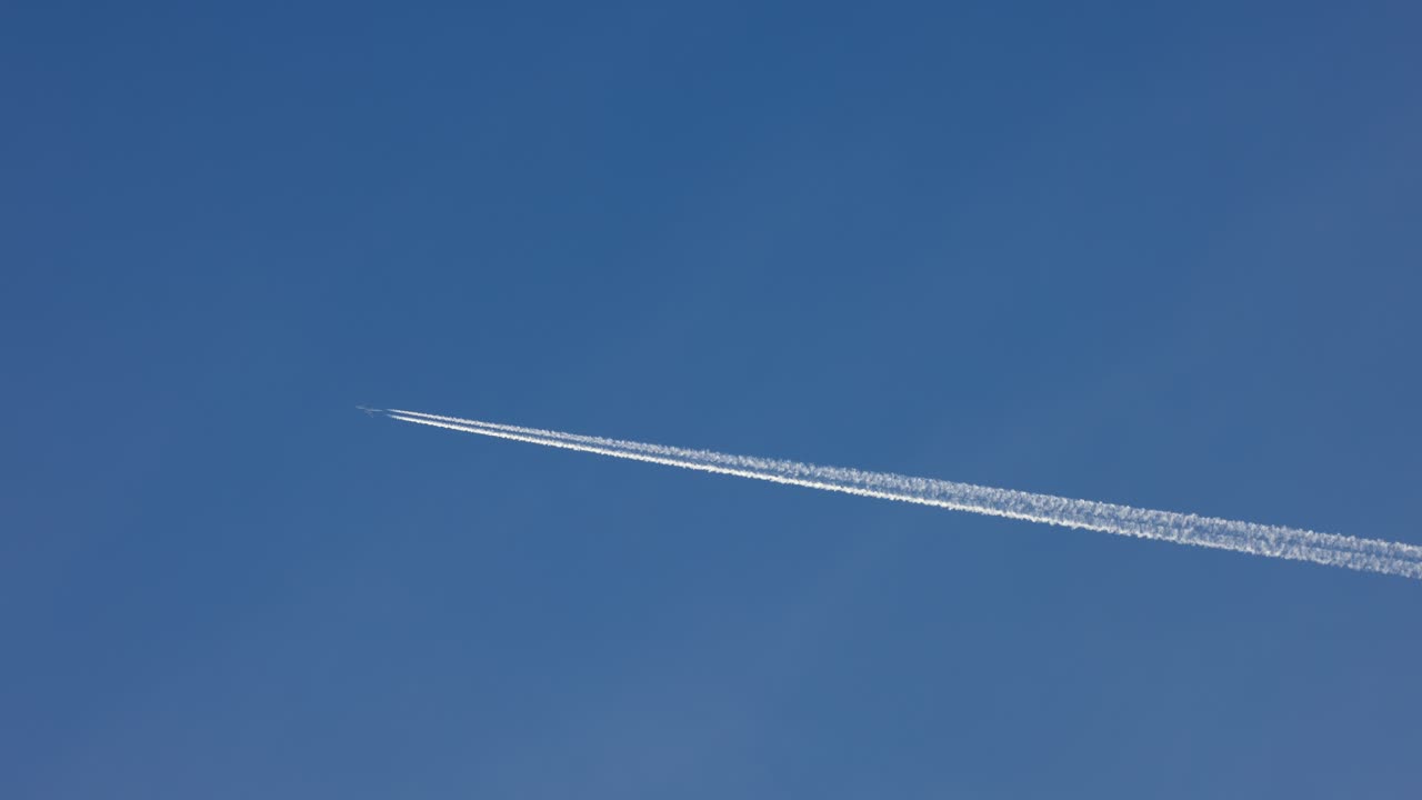 самолет создает облака, пролетая над голубым небом