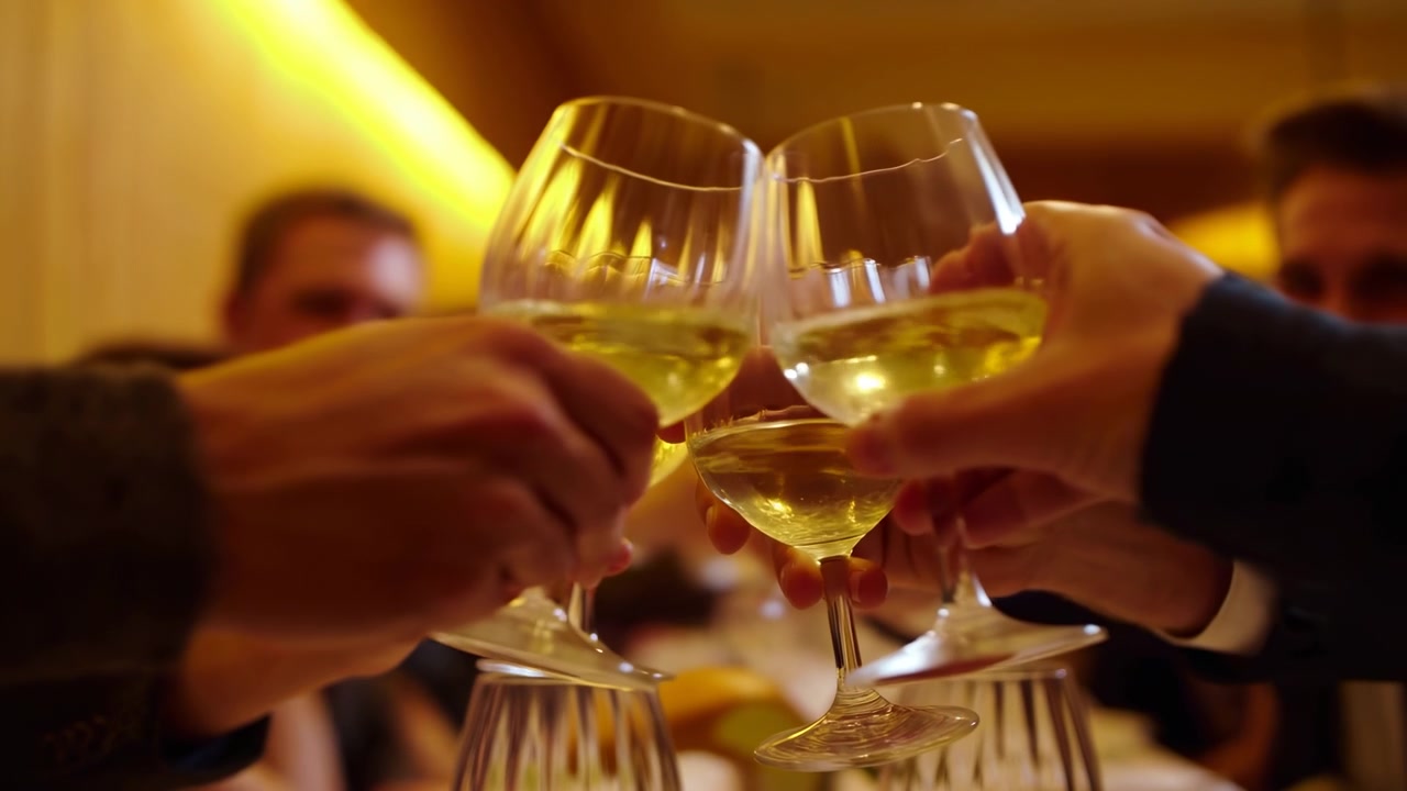 Friends Clinking Wine Glasses Warm Bistro Intimate Evening Dinner Scene With White Wine In Stemmed Glasses,