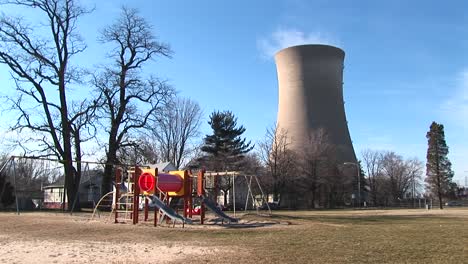 a children's colorful playground is seen in the foreground with a nuclearpower plant in the background