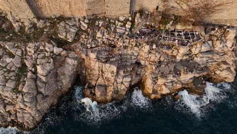 aerial view of coastal cliffs and fortress with people