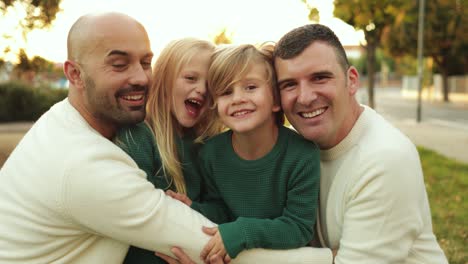 familia lgbt al aire libre - hombres gay felices padres e hijos divirtiéndose juntos en el parque de la ciudad