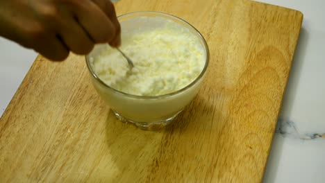 close up of person hand stirring milk powder into milk