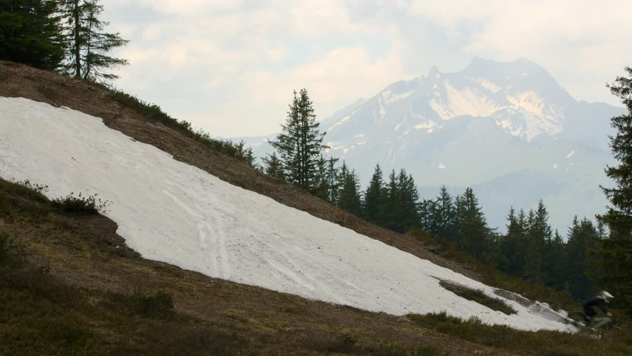 ciclista de montaña recorre un parche de nieve a alta velocidad