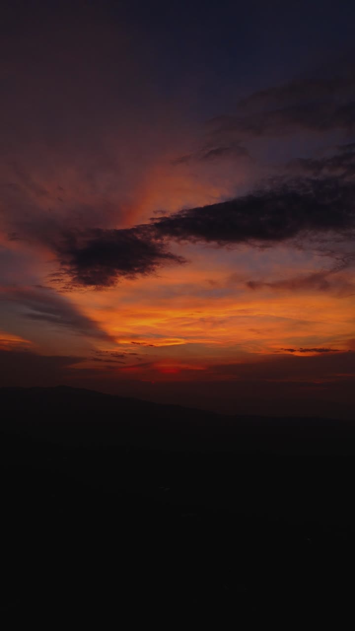 A dramatic sky with orange, black, and blue hues after sunset, creating a mesmerizing atmosphere.
