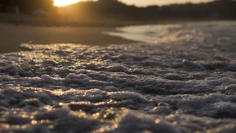Nahaufnahme-Einer-Welle-In-Zeitlupe-Am-Sandstrand-Mit-Sonnenuntergang