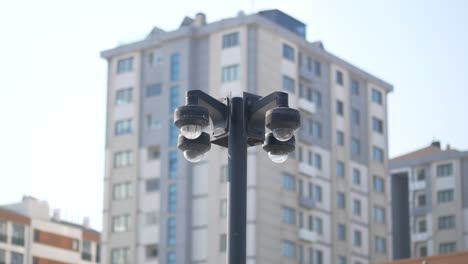 security cameras on a lamp post in front of buildings