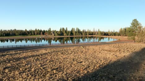 Wide-drone-shot-pulling-away-from-a-private-bass-pond-in-Bend,-Oregon