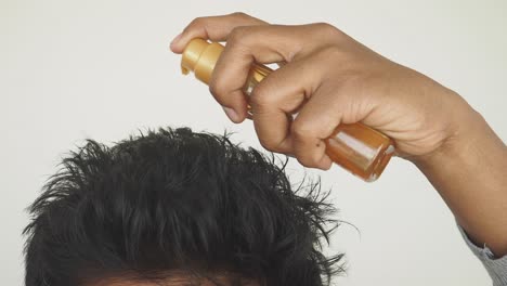 man applying hair spray