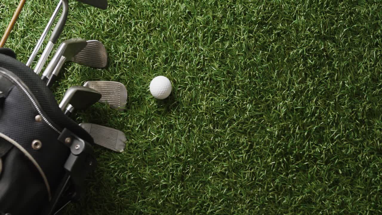 Primo piano di mazze da golf e pallina sull'erba, spazio per il testo, movimento rallentato.