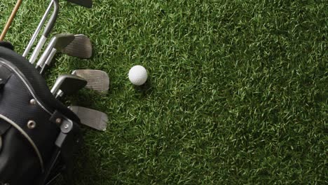 Close-up-of-golf-clubs-and-ball-on-grass,-copy-space,-slow-motion