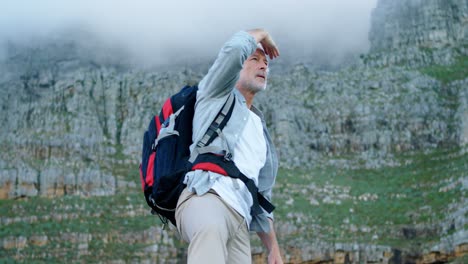 senior man shielding his eyes while standing at countryside 4k