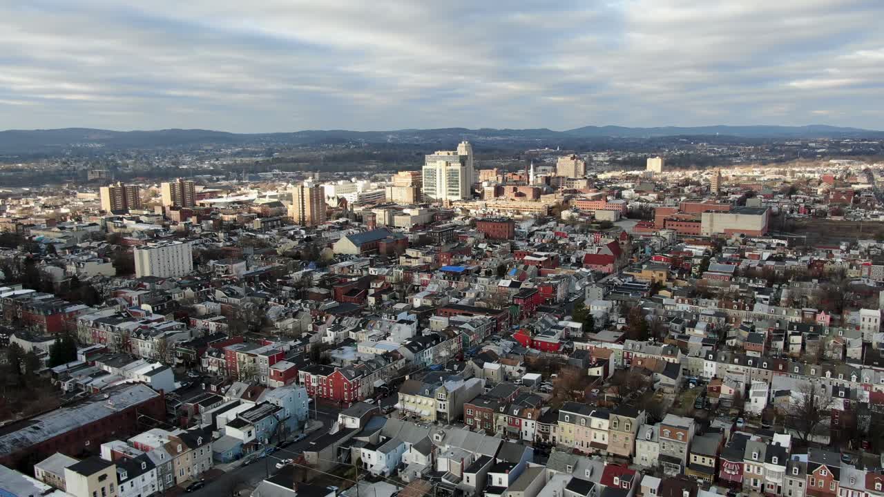 Aerial drone view above City of Reading, Pennsylvania, USA, low income housing projects in urban America, downtown skyscrapers in distance, establishing shot
