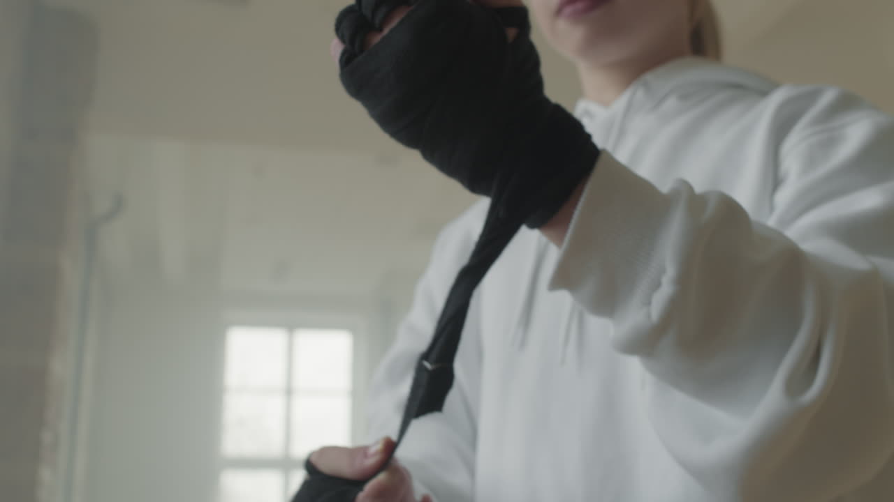 Young Sportswoman Wrapping Hands Before Kickboxing