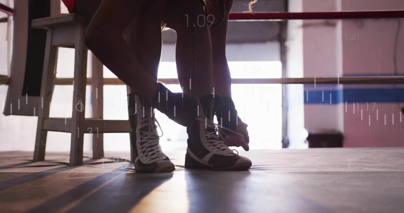 Atleta løfter foten og knyter boksesnører i ringen for trening, med sanntidsmålinger som oppdateres.