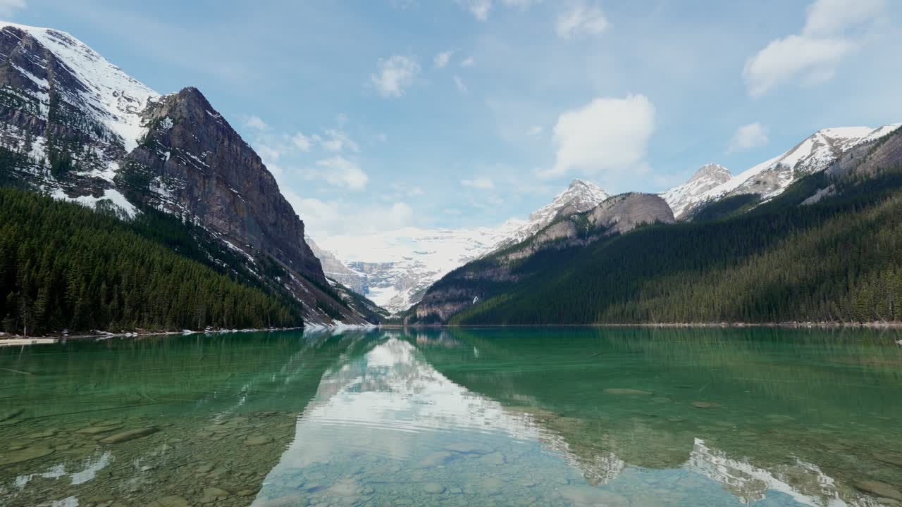 Acqua turchese del Lago Louise che riflette montagne innevate e foreste nel Parco Nazionale di Banff.
