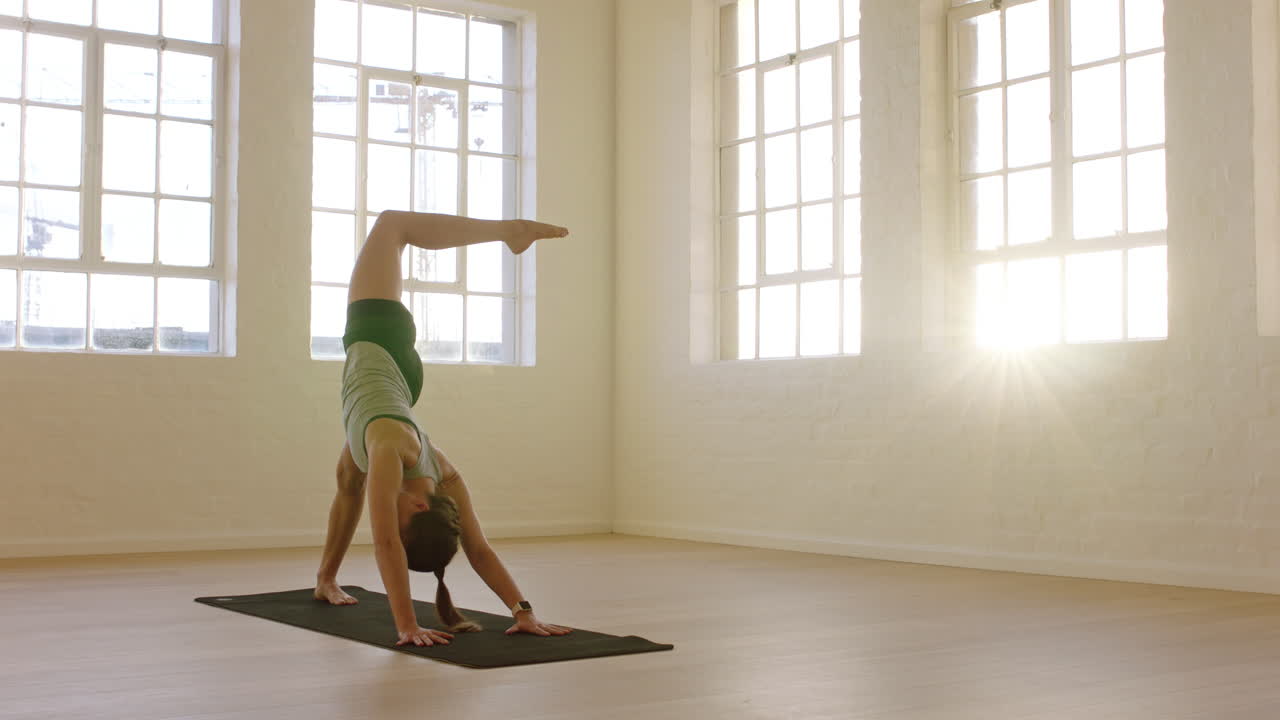 gesunde yoga-frau praktiziert die pose eines dreibeinigen, nach unten gerichteten hundes und genießt den fitness-lebensstil beim training im trainingsstudio, stretching-training auf der trainingsmatte bei sonnenaufgang