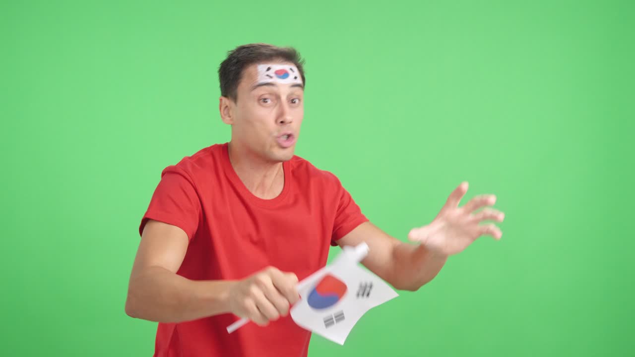 Man cheering for South Korea waving a national flag looking away