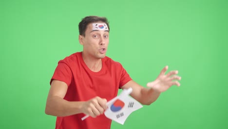 man cheering for south korea waving a national flag looking away