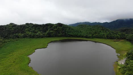 el lago del cráter volcánico refleja el cielo nublado en el parque nacional grand etang, establecimiento panorámico aéreo