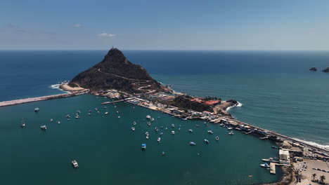 Panoramic-drone-shot-around-the-Isla-El-Crestón,-sunny-day-in-Mazatlan,-Mexico